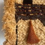 Add a unique twist to your outfit with this stunning straw handbag. Hand-embellished with pearled, sequinned silk and a bright orange pom pom. 