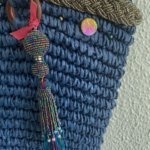 This beach tote bag is made from raffia and is hand embellished with pearled braid, crystal pearls, shells and pearled pom pom.