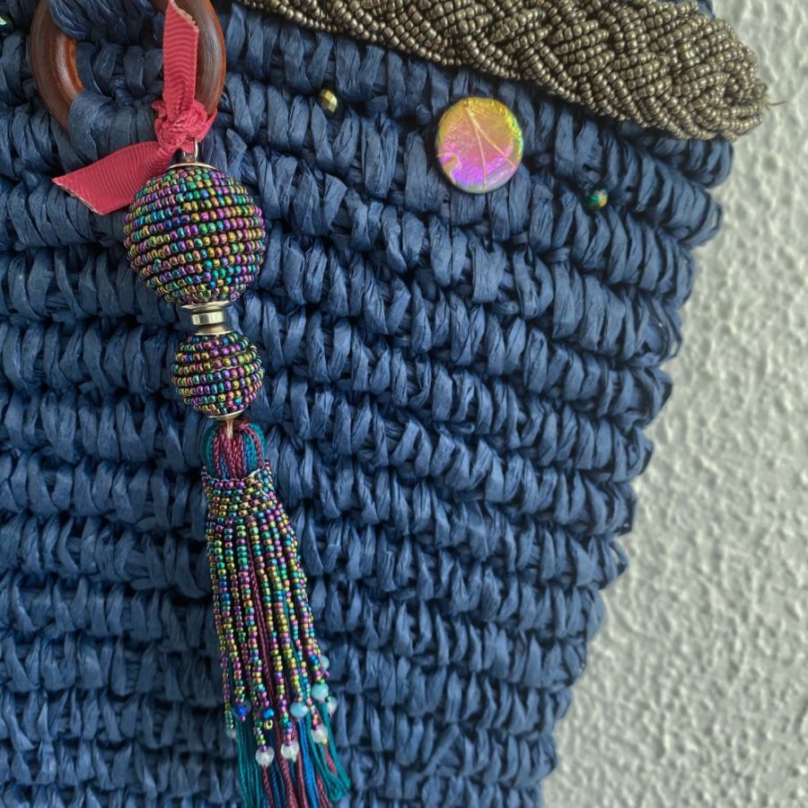 This beach tote bag is made from raffia and is hand embellished with pearled braid, crystal pearls, shells and pearled pom pom.